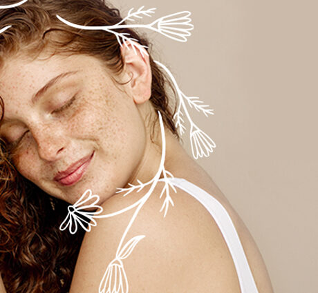 Junge langhaarige Frau genießt es Ihr gepflegtes Harr zu berühren und verschließt dabei die Augen